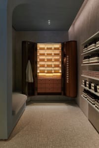 Modern retail store showcasing wooden shelves, glass bottles, and concrete flooring