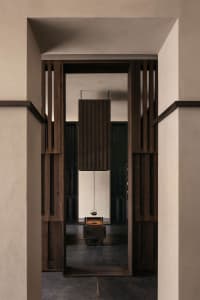 A modern tea room with wooden walls and a hanging kettle over a wooden table.