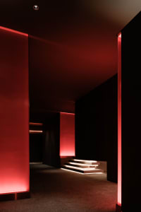 A minimalist lobby interior with red lighting