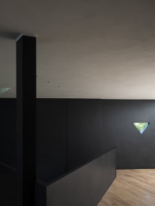 A minimalist black interior with a metallic window