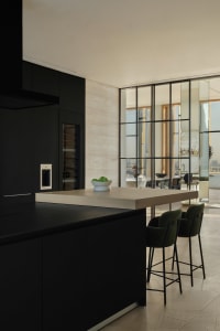 Modern kitchen featuring black cabinets and wood countertops.