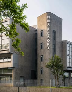 A modern office building with a grey concrete exterior and large windows.