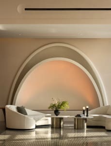 A minimalist lobby with a sleek marble interior and curved arches.