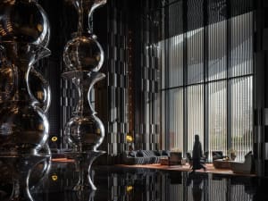 A modern hotel lobby featuring metallic decorative elements and a sleek, contemporary interior design.