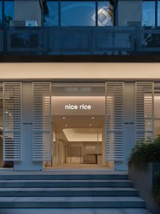 A modern storefront with glass panels and illuminated signage.