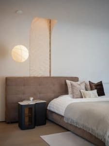 Modern minimalist bedroom featuring plush velvet bedding, marble nightstand, and wooden accents, showcasing sophisticated des
