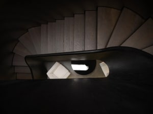 A modern interior staircase with wooden steps and a curved design.
