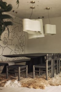 A modern dining room featuring wooden furniture, including a long dining table and chairs.
