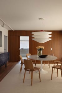 Modern dining room featuring wooden chairs and a marble table.