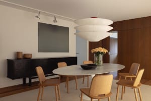 A modern dining room featuring a marble table and wooden chairs.