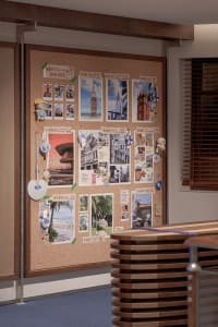 A corkboard filled with travel-related photographs and mementos.