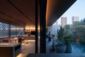 A modern residential pool deck featuring wood and concrete elements.