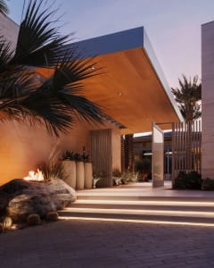 Exterior view of a modern entrance featuring concrete steps and glass doors, set against a dusk sky.