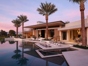 Modern residential exterior featuring neutral colors, glass, and concrete materials.