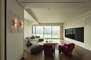 Modern minimalist living room with white walls, hardwood floors, and floor-to-ceiling glass windows.