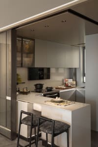 A modern, minimalist kitchen featuring marble countertops and sleek, contemporary cabinetry.