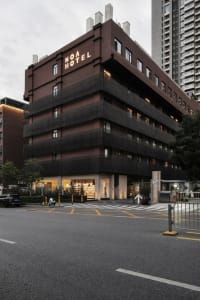 A modern hotel building with a black concrete exterior.