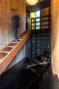 A modern living space featuring a wooden staircase with black accents.
