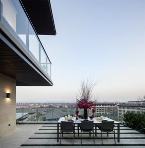 A modern dining room with transparent glass panels and a view of the cityscape.