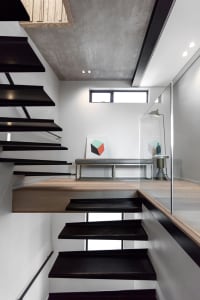 Black metal staircase with concrete floor and minimalist decor.