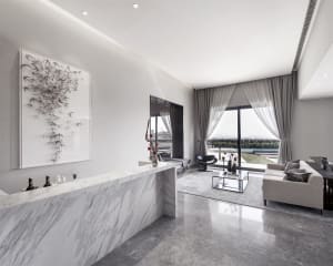 Modern minimalist living room featuring marble accents, glass doors, and sleek furniture.