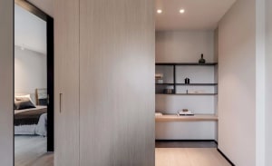A modern minimalist closet with wooden elements and built-in shelves and storage.