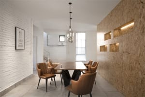 An industrial-style restaurant interior featuring brick, concrete, oriented strand board (OSB), and leather furniture.