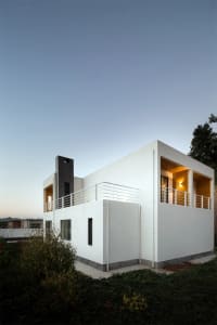 A modern house with a white, concrete exterior.