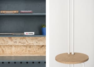 A minimalist interior design featuring a wood shelf with a blue plant pot and model trains.