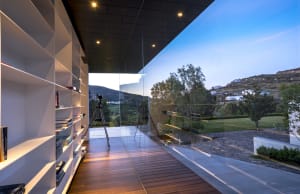 A modern library with a glass wall overlooking a scenic landscape.