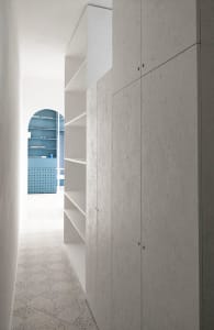 Modern minimalist wardrobe interior with concrete cabinets and shelves.