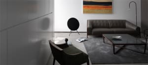 A modern living room with a minimalist sofa, coffee table, and abstract painting.