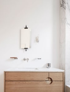 A modern bathroom with a wooden vanity, marble countertop, and a minimalist design aesthetic.