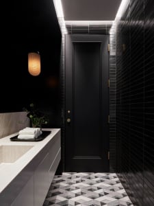 Modern minimalist black bathroom with marble floor and white accents.