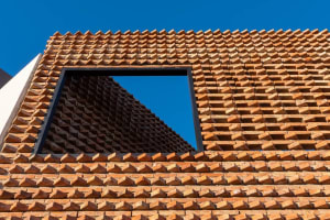Clay tile roof with a unique geometric pattern and a framed window.