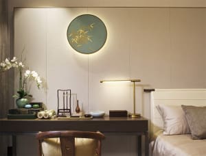 Modern bedroom featuring walnut wood furniture, fabric bedding, and porcelain decor items.