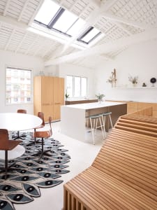 Modern, minimalist residential kitchen featuring white wood cabinets and a central island.