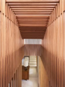 Interior view of a hallway with a wooden staircase and wood-paneled walls.