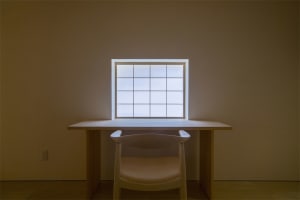 Modern workspace featuring a wooden desk and glass window.