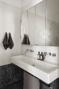 Minimalist bathroom with organic shapes, white and grey color scheme, and ceramic tiles.