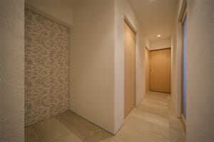 A minimalist house hallway with wooden walls and doors.