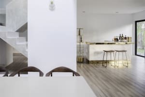 A modern minimalist dining room featuring concrete and marble materials, with a white dining table and wooden chairs.
