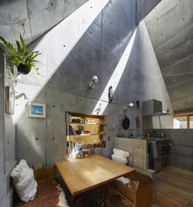 A cozy industrial kitchen with wooden table and concrete walls