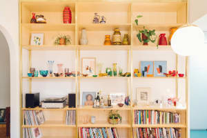 A modern interior with wooden bookshelves displaying books and decorative items.