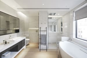 Contemporary bathroom featuring marble walls and a wooden floor.