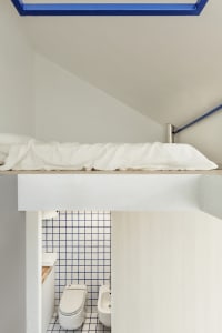 A minimalist bedroom with blue and white checked tile walls.