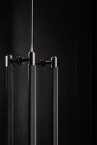 Close-up of modern lighting fixtures with a textured metal surface against a dark background.