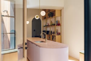 A minimalist kitchen with a terrazzo countertop and a large window.