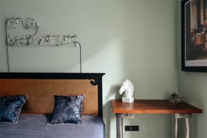 A modern bedroom featuring a concrete headboard and minimalist decor.