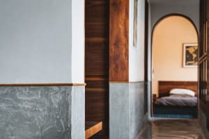 A minimalist bedroom with concrete, wood, and metal elements.